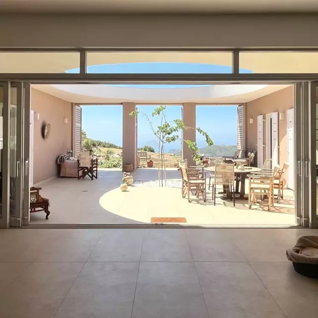 Villa Katerina 2. There are huge sliding doors between the living space and the courtyard so the spaces merge. Both address the spectacular vista of the Mediterranean to the south. The house is oriented so that the focus of the view is the majestic rock which rises from the sea beyond the port of Kapsali.

#greekisland #kythira #oculus #courtyard #courtyardhouse #bluesky #doglovers #views #islandliving #architectinoxford #kapsali #indooroutdoorliving